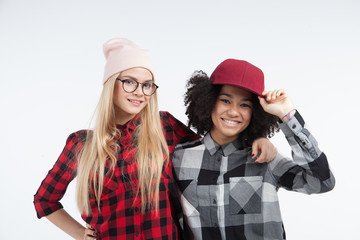 Studio lifestyle portrait of two best friends hipster girls going crazy and having great time together. Isolated on white background.