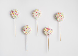 Candy lollipops with sprinkles on white background