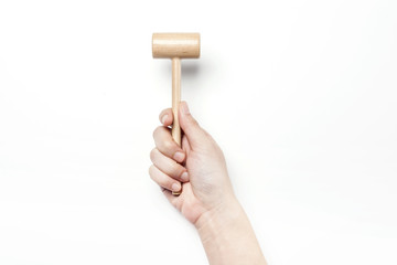 woman hand hold a small wood hammer isolated white.