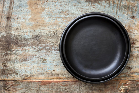 Empty Rustic Black Plates over Grunge Timber Top View