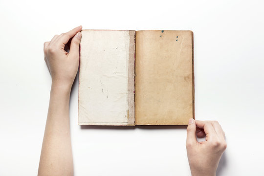 woman hand hold a vintage book isolated white.