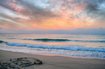Sunset on the beach. Colorful dawn over the sea. Dramatic sky