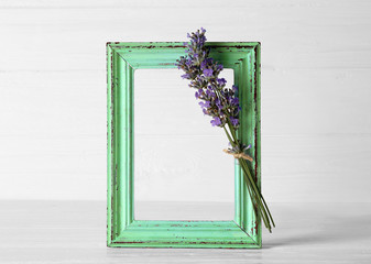 Old green frame with lavender on light background