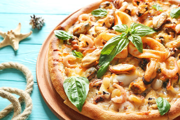 Delicious seafood pizza on turquoise wooden background, close up