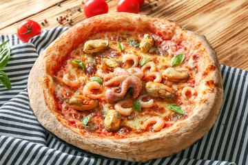 Gourmet seafood pizza and napkin on wooden background
