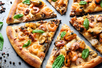 Cutting fresh seafood pizza on grey background