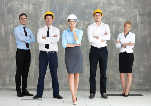 Team Of Young Creative Engineers On Grey Wall Background