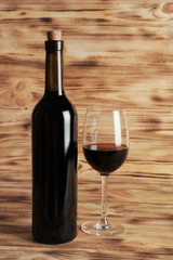 Wine bottle and glass on wooden background
