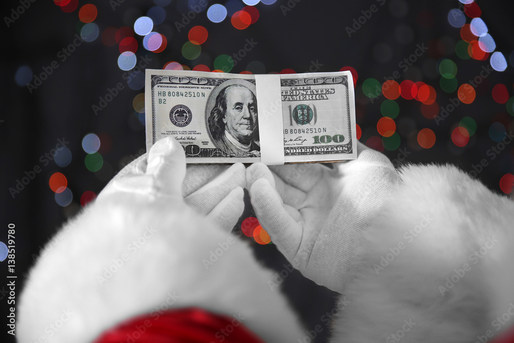 Poster santa claus hands holding money on blurred lights background