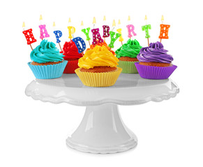 Tasty colorful cupcakes with Happy Birthday candles and plastic stand on white background