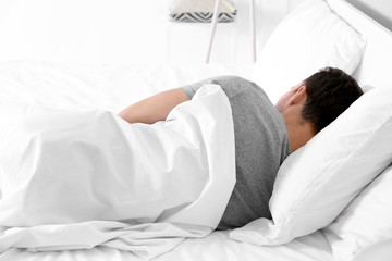 Tired young man sleeping in bed