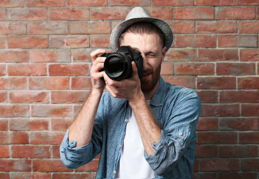Handsome photographer near brick wall