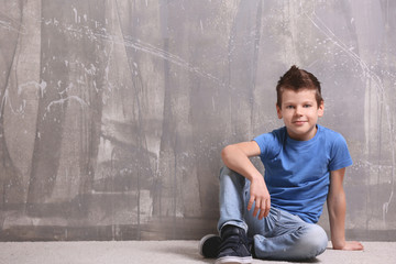 Cute little boy on grey textured background