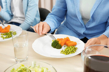 Obraz na płótnie Canvas Woman eating vegetables during lunch at home, closeup