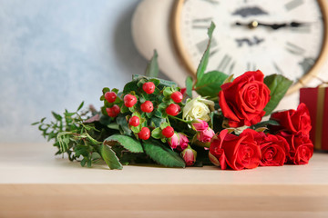 Bouquet of beautiful roses on wooden table