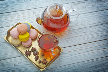 Cup of tea with delicious macaroons on copper tray