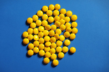 Yellow candies on blue background