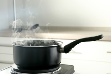 Metal saucepan on electric stove in kitchen