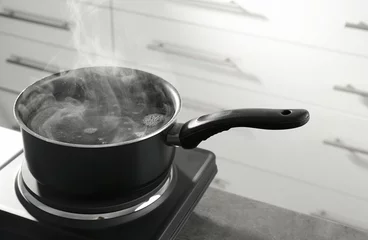  Metal saucepan on electric stove in kitchen © Africa Studio
