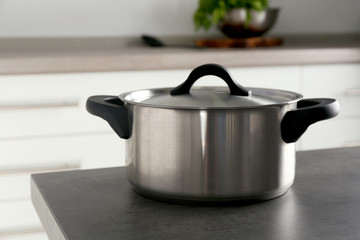 Metal saucepan on table in kitchen