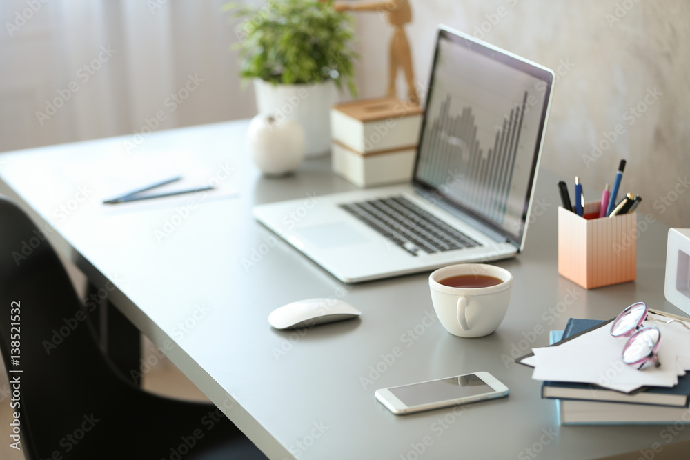 Wall mural Workplace with laptop on table in modern room