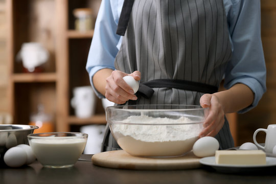Cooking concept. Woman making dough on kitchen