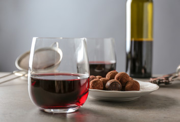 Red wine and chocolate truffles on table