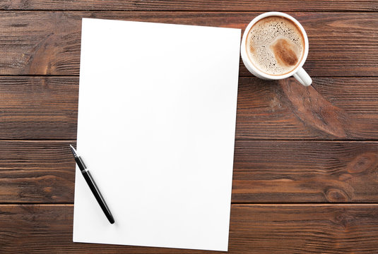 Cup Of Coffee And Paper With Pen On Wooden Table