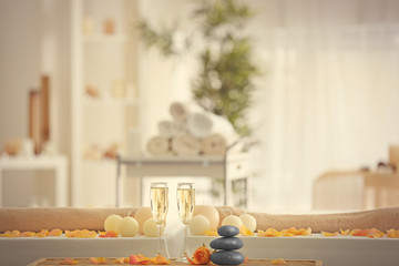 Beautiful spa composition with glasses of champagne on blurred background