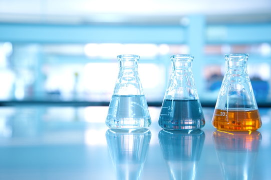 three flask of water black orange solution in science laboratory