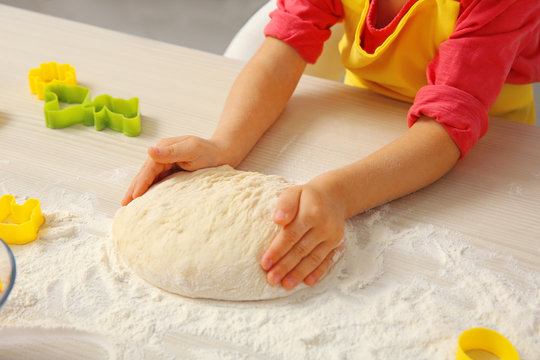 Little girl making dough for Easter cookies, closeup