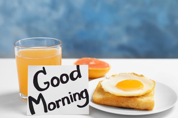 Note with phrase GOOD MORNING and tasty breakfast on table