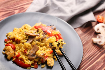 Traditional rice on black chopsticks, closeup