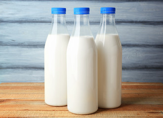 Bottles of tasty milk on wooden table