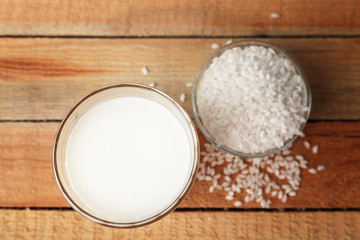 Glass of tasty rice milk on wooden table