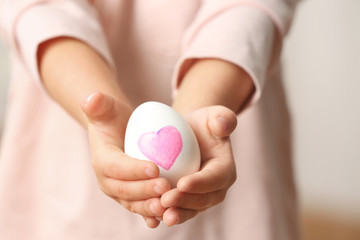 Hands of cute little child holding Easter egg, closeup