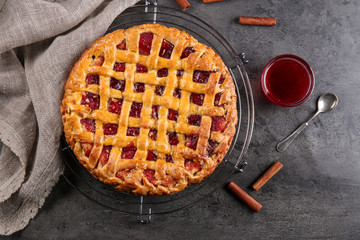 Metal stand with delicious berry pie on gray background
