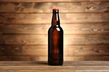 Abwaschbare Fototapete Bier Bottle of beer on wooden background