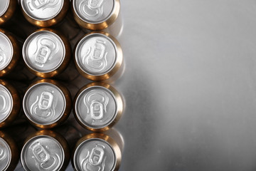 Cans of beer on gray table, top view