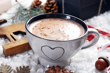 Cup of cocoa and Christmas decoration on soft fabric background
