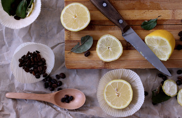 process of cooking in the kitchen, boy holding half a lemon in his hands, on the table next to slices of lemon and coffee beans and spices