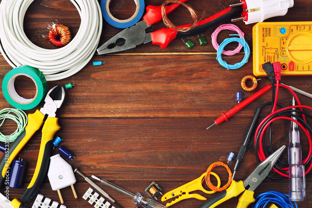 Poster Different electrical tools on wooden table, top view