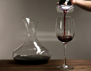 Pouring wine in glass on wooden table