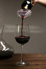 Pouring wine in glass on wooden table