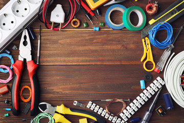 Different electrical tools on wooden table, top view