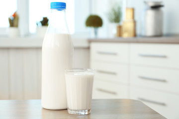 Bottle and glass of milk on table in kitchen