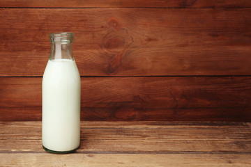 Bottle of milk on wooden background