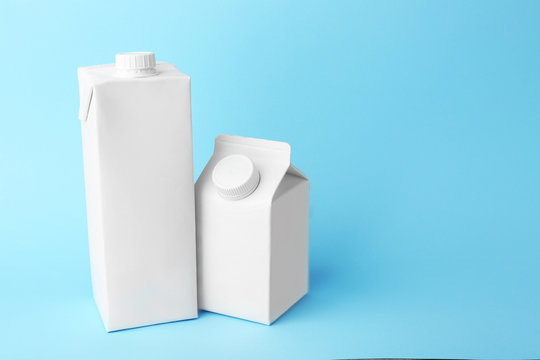 Two simple milk boxes on color background