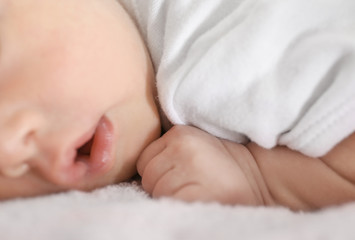Cute funny baby lying on bed at home, closeup