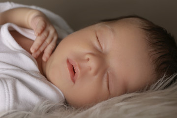 Cute little baby sleeping on soft plaid, closeup